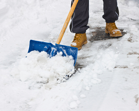 snowboots and person shoveling